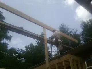 Carpenter setting a ridge beam over a new addition frame — Ice Dam Removal by Roofing Brothers in Le Grand