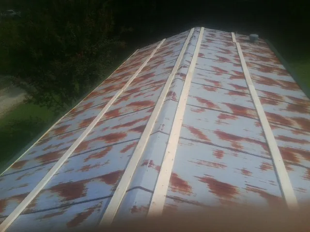 Rusted metal roof panels with new wood purlins before replacement — Storm Damage Roof Repair in Le Grand by Roofing Brothers