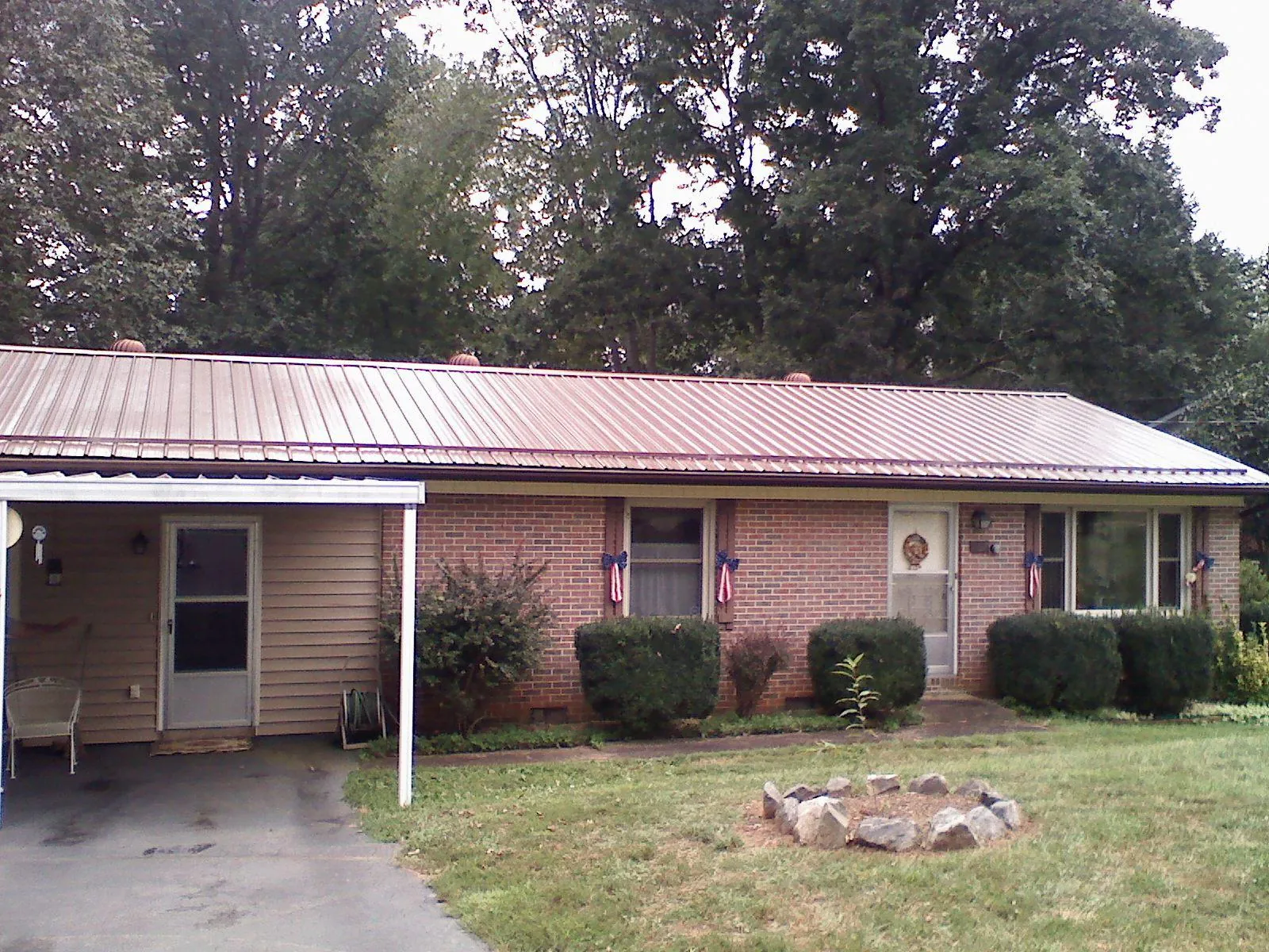 Bronze metal roof and carport on a brick ranch home — Roof Repair work by our crew in Le Grand